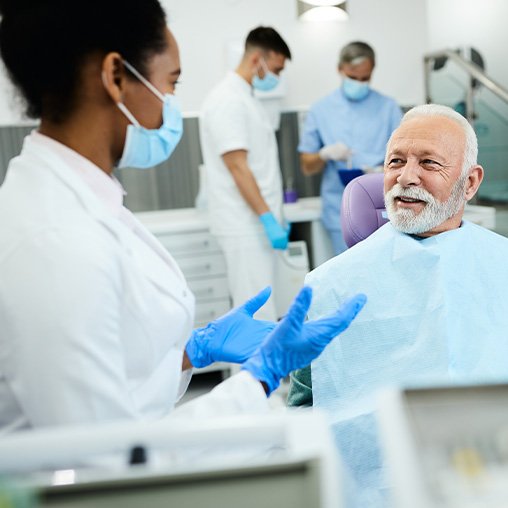 Man smiling while talking to dentist during consultation