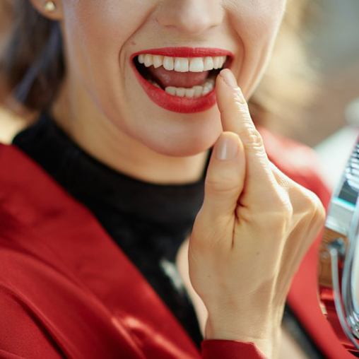 Woman examining her teeth in mirror