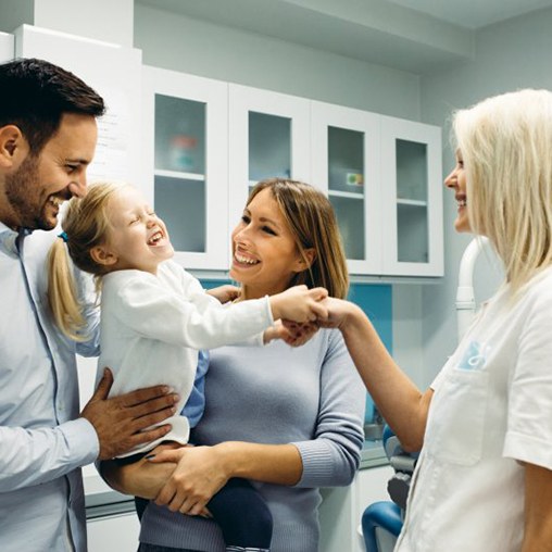 Young family meets with dentist for their daughter’s checkup